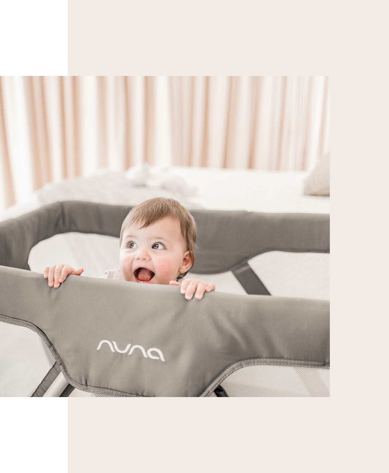 Smiling boy inside a Nuna SENA play yard