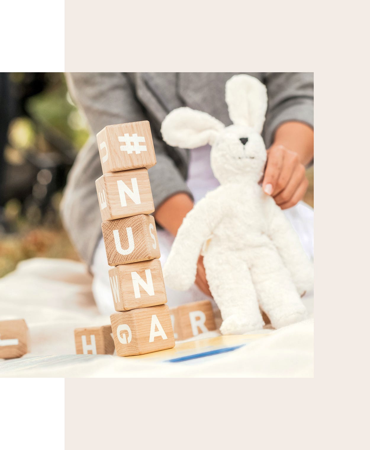 Stacked children's blocks that spell #NUNA and women holding a white stuffed animal bunny