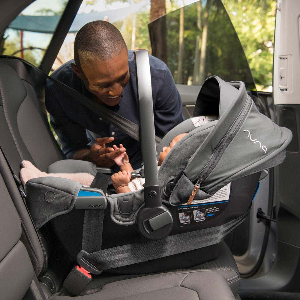 Father smiles at infant in PIPA rx car seat in vehicle 
