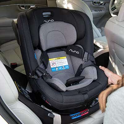 Mom adjusting REVV car seat in vehicle