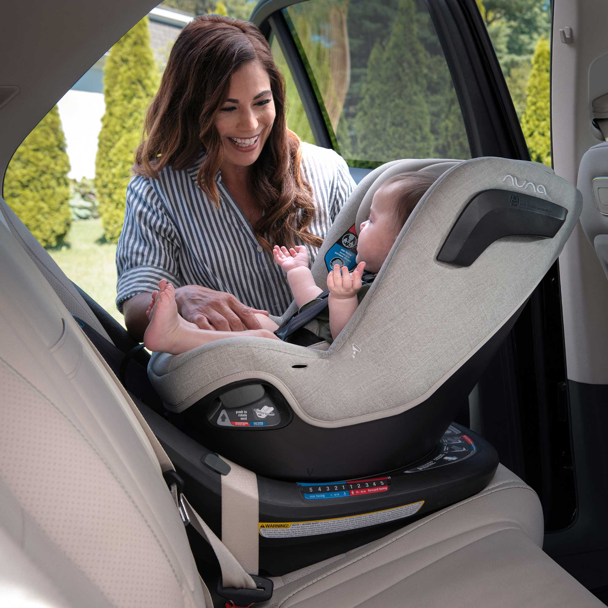 Mom smiles at young child in REVV car seat