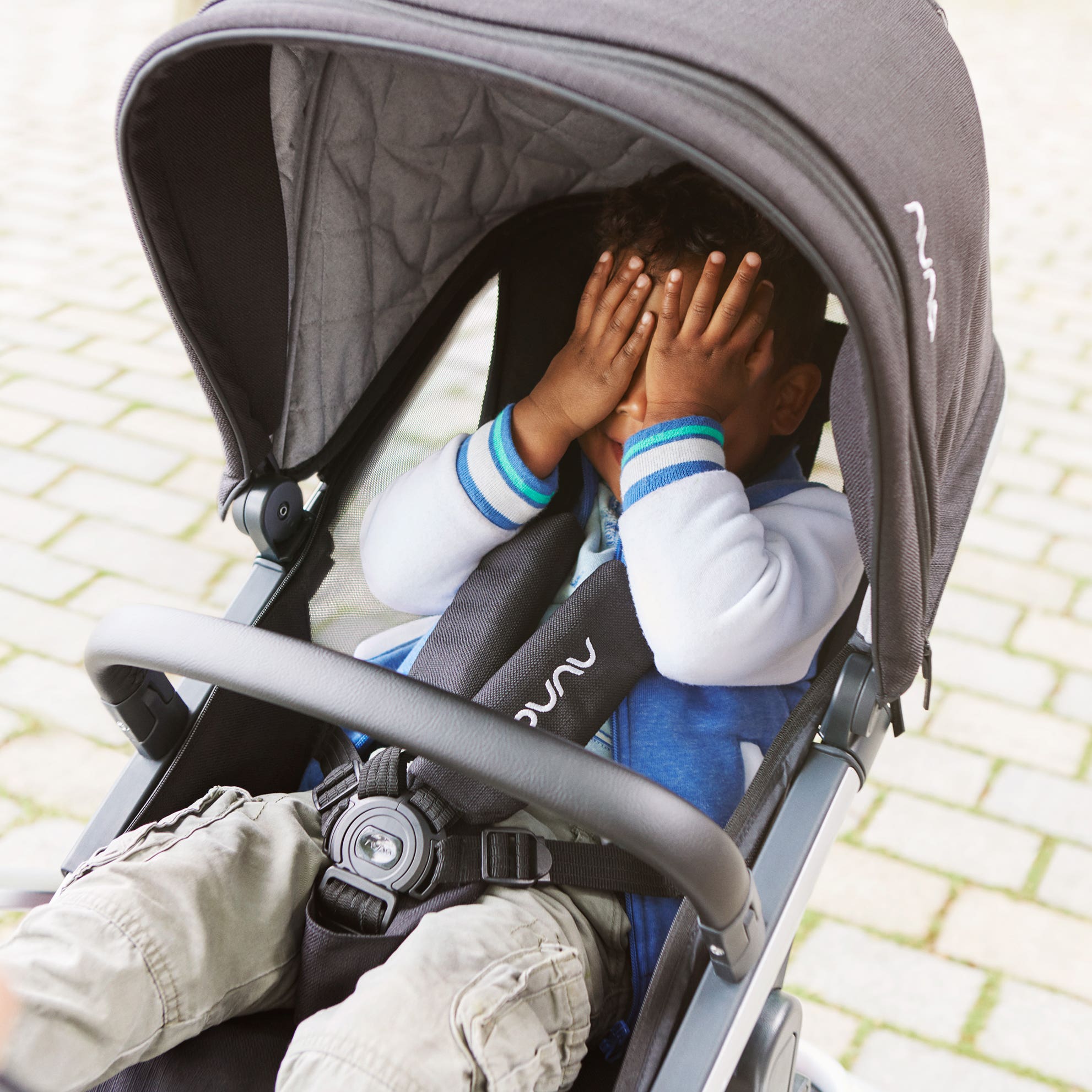 Boy in IVVI totl stroller covers his face with his hands